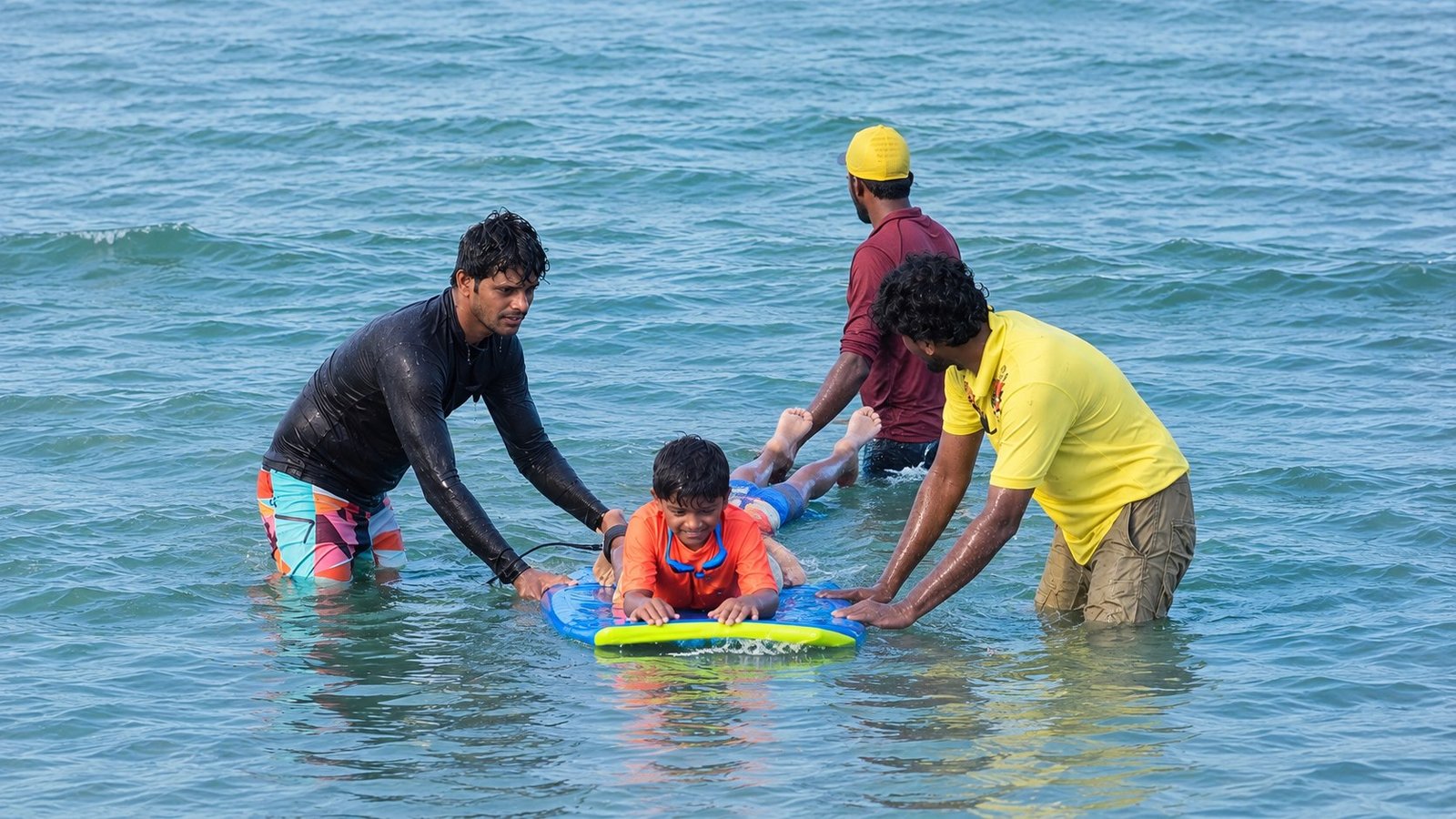 Coaches helping a young swimmer on a bodyboard
